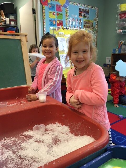 girls playing in a sensory bin