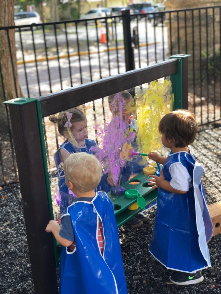 small children painting together at an easel